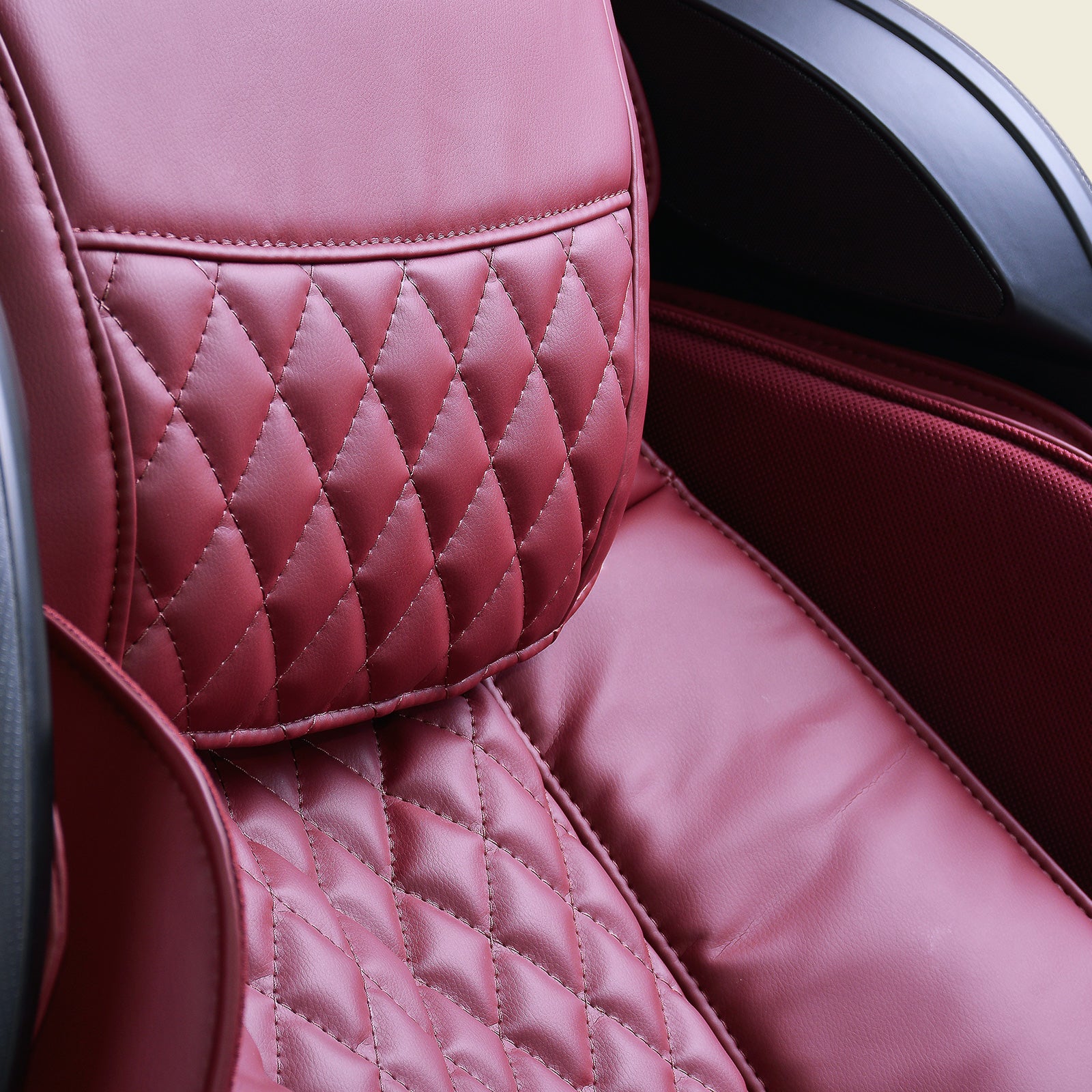 Close-up of a red JPMedics Kumo Massage Chair with diamond-patterned leather stitching.